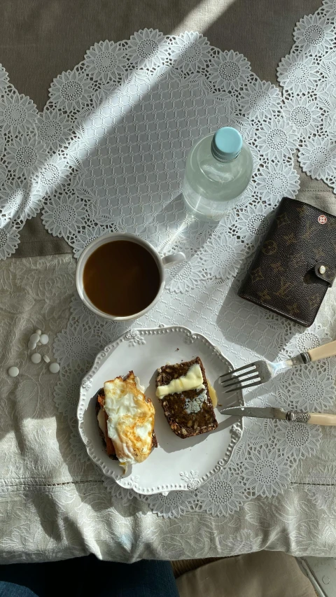 a table has a plate with four deserts and a cup of coffee