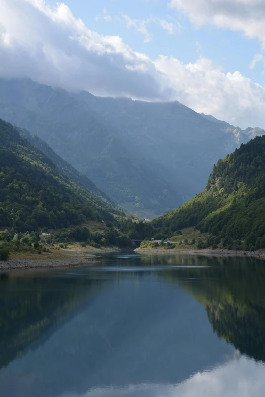 a lake surrounded by forest near mountains