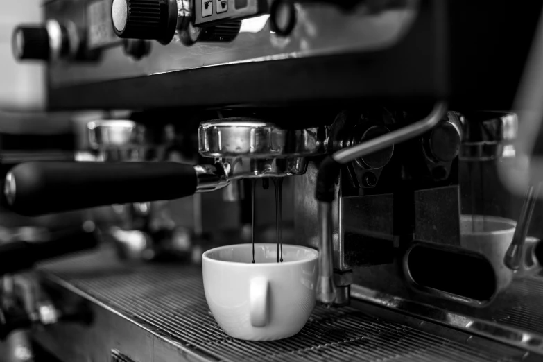 black and white pograph of coffee being poured into a cup