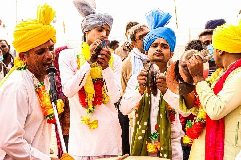 many people are wearing colorful saries and holding soing