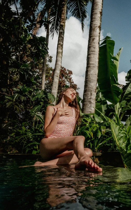 a woman sitting in a pool of water with her eyes closed