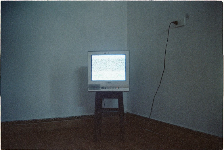 a small tv on a tripod in a corner