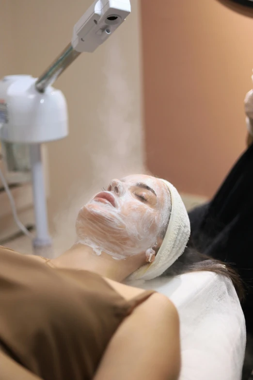 a woman getting facial mask treatment in the salon