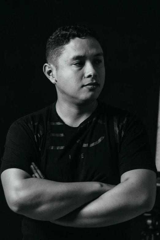 black and white portrait of a young man with arms crossed