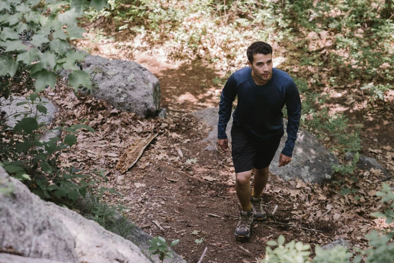 a man with water and rain gear walking on a trail