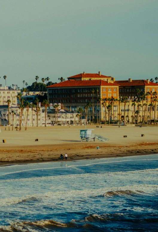 a beach with buildings and people on the sand