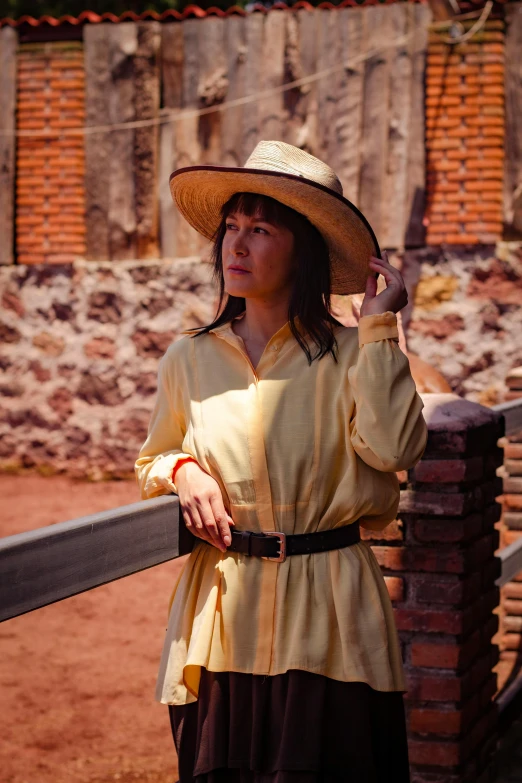 a woman wearing a hat is posing for a picture