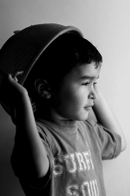 a black and white po of a small boy with a hat on his head