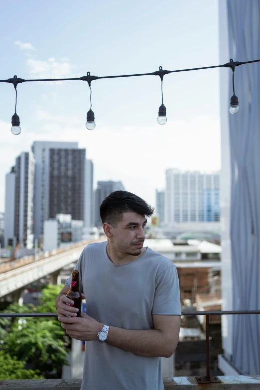 a man is standing under lights while holding a drink