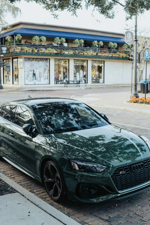 green sports car parked in front of a store on brick pavement