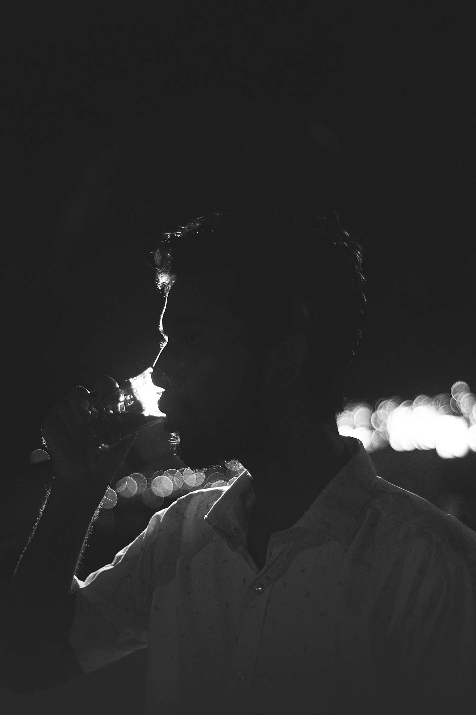 a person in a dark background with the flashlight on their face