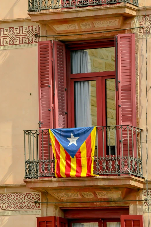 an american flag hangs in a balcony of a building