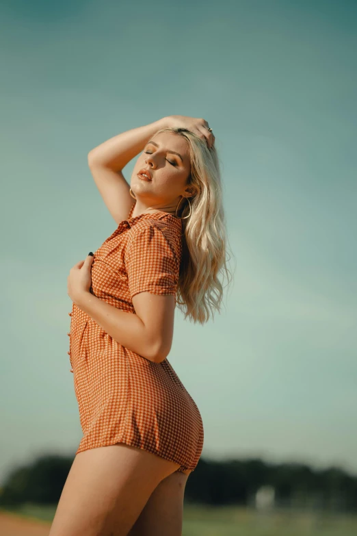 a woman in an orange shirt is posing