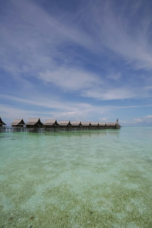 a beach on an overcast day, with a resort in the distance