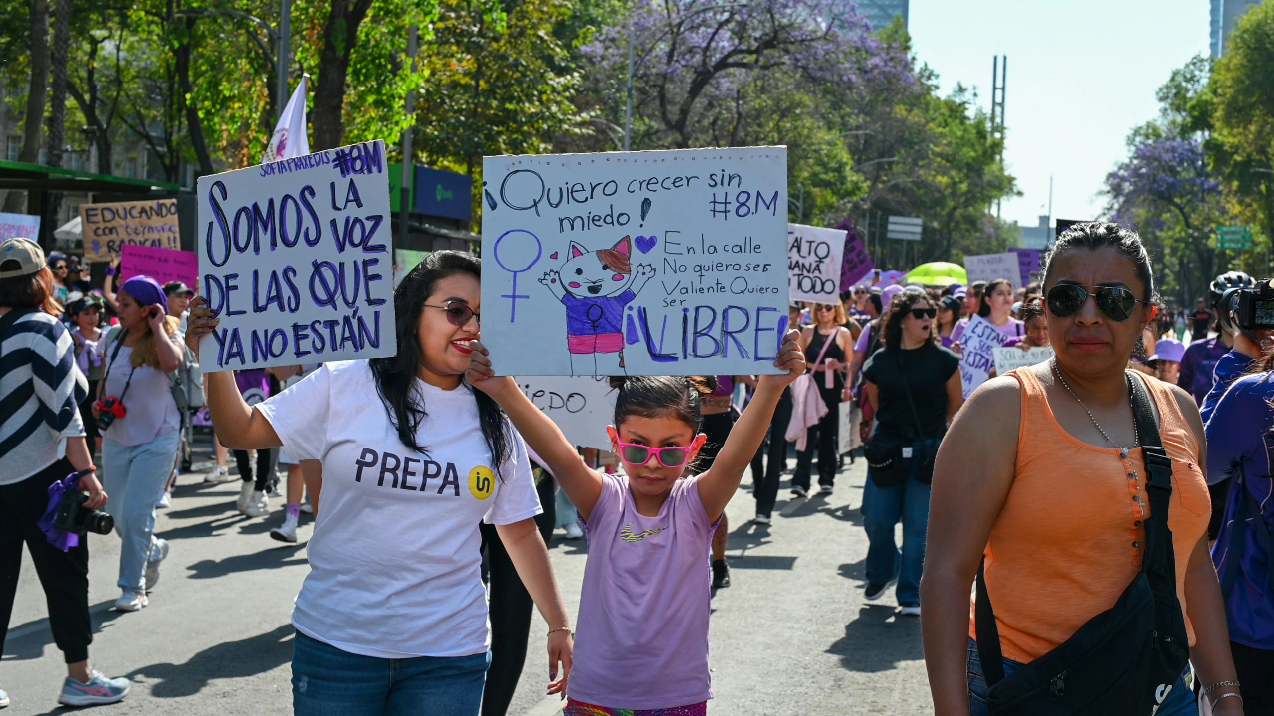 a group of people marching down the street holding up signs