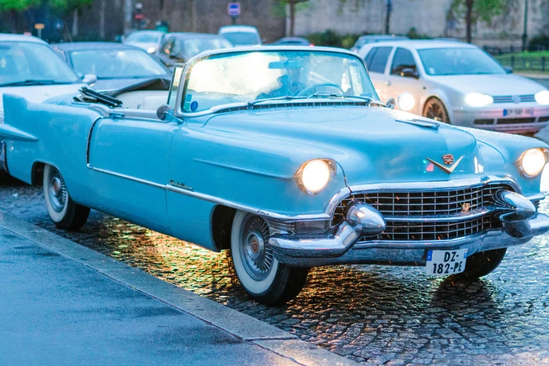 there is a blue car parked in front of a row of white cars