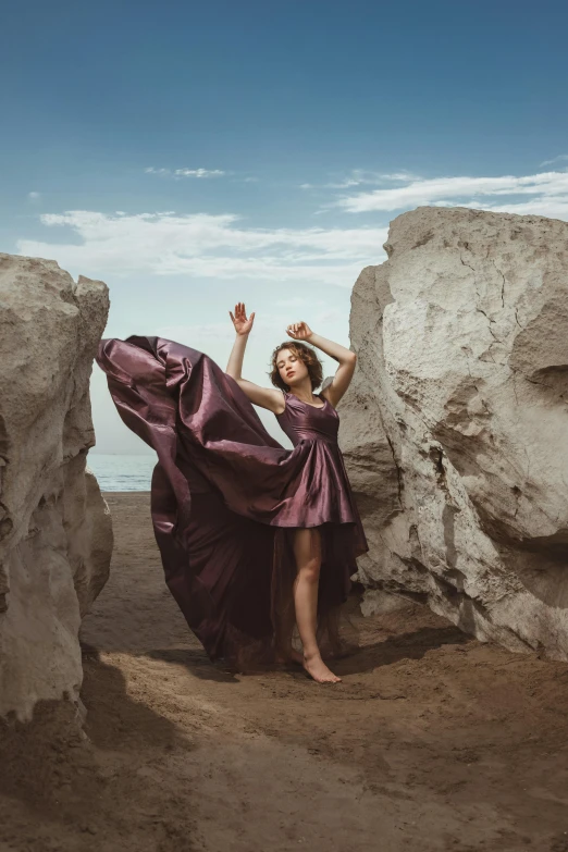 a woman with a hairdo stands in between two huge rocks