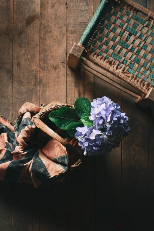 a vase with purple and blue flowers and some green leaves