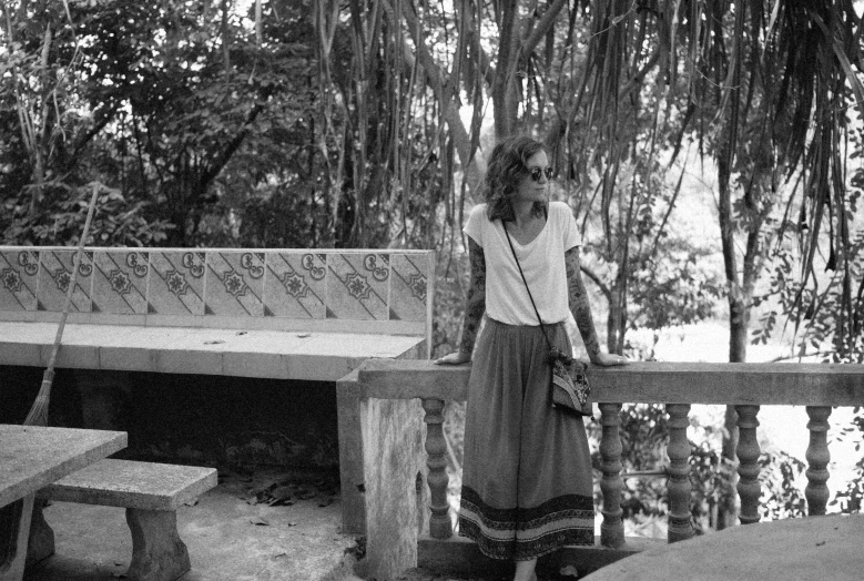 a black and white po of a woman near a bench