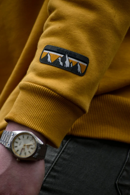 a person wearing a yellow shirt with a wrist watch