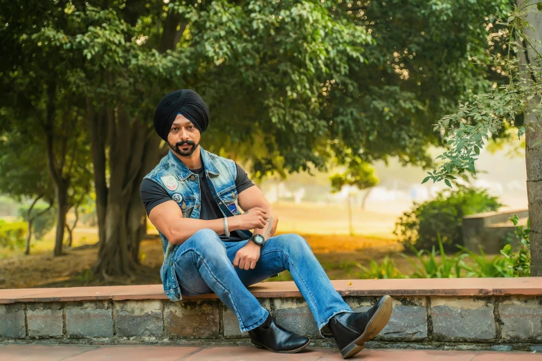 a man in a beanie sitting on a stone wall