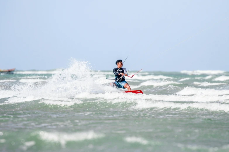 man kite boarding in the ocean with strong waves