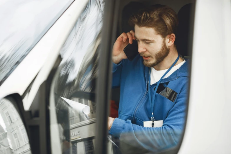 a man sitting inside a car talking on the phone