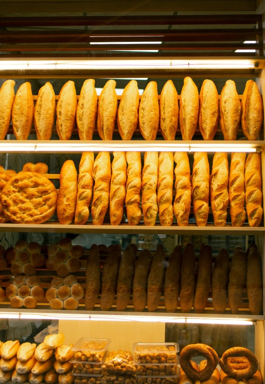 a large display in a bakery filled with breads and rolls