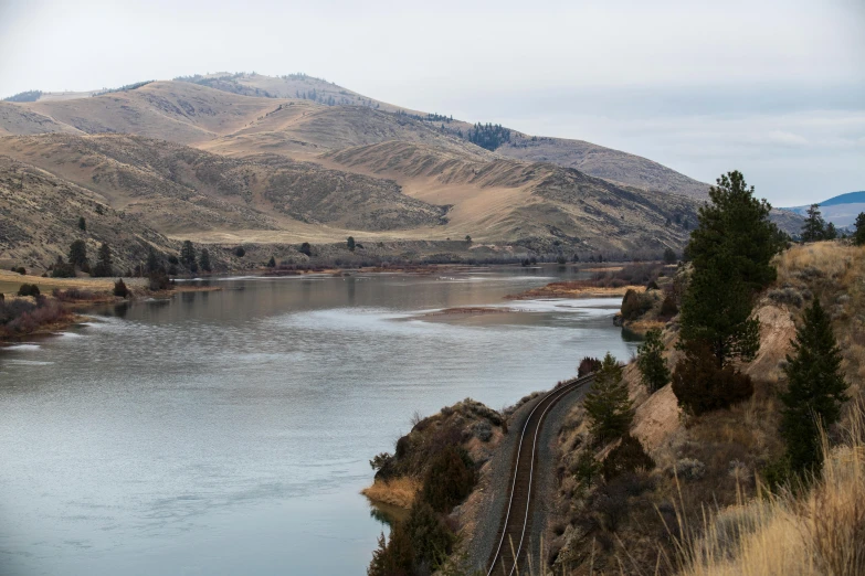 the mountain top is behind the train tracks