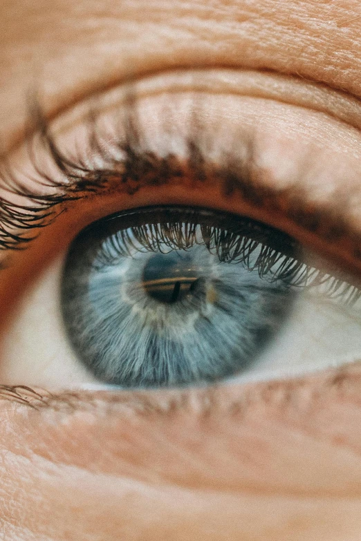 an eye with blue colored iris and white - tipped edges