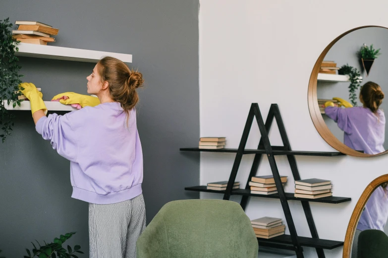 the woman is drying a shelf with a sponge