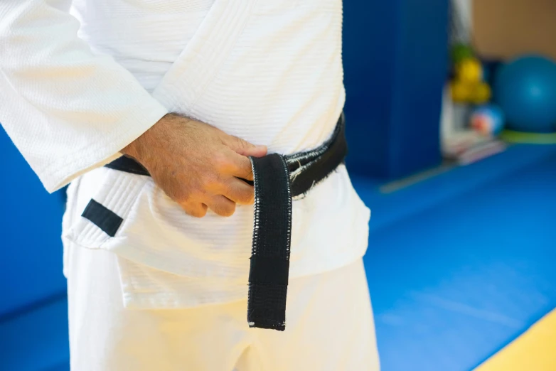 a person standing in a gym room with a black belt