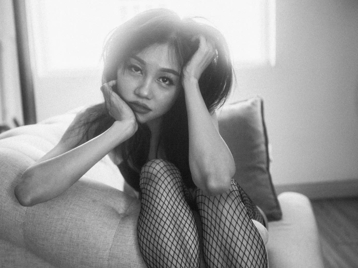 a woman sitting on the couch and posing with a pillow