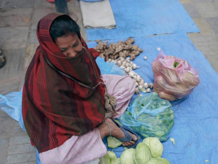 a woman sitting on the ground preparing food