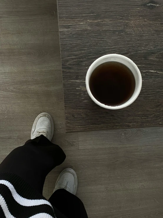 person with their feet on a table in front of a cup of tea