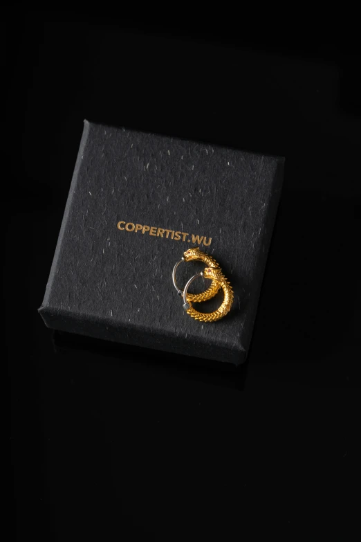 a yellow and black piece of jewelry in a box