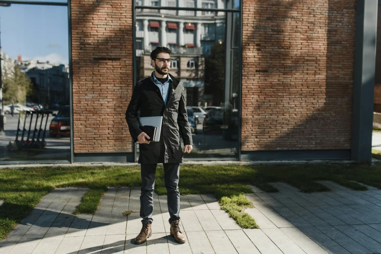 man with glasses is holding a white folder