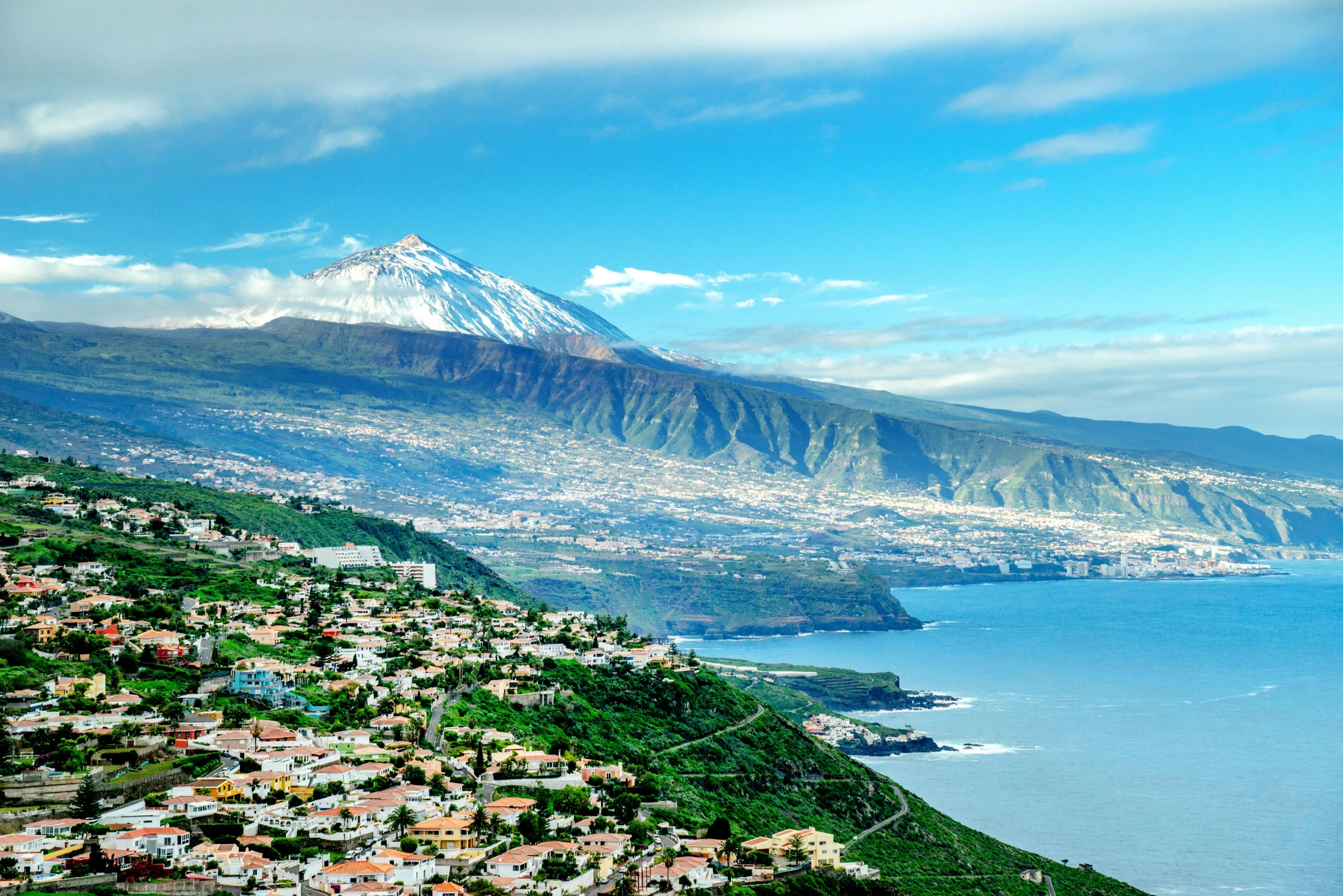 the mountains are tall with small houses on them