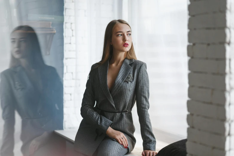 woman with her legs crossed in a grey suit