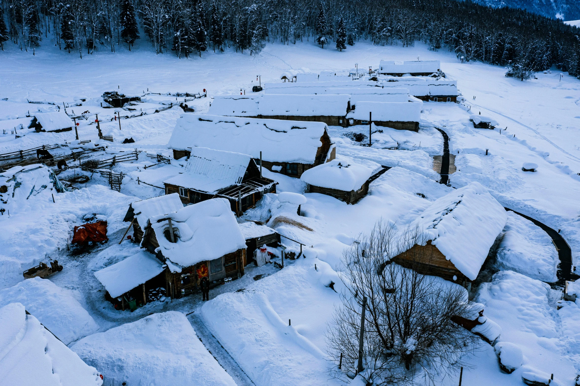 an aerial view of snowy village nestled along the mountain