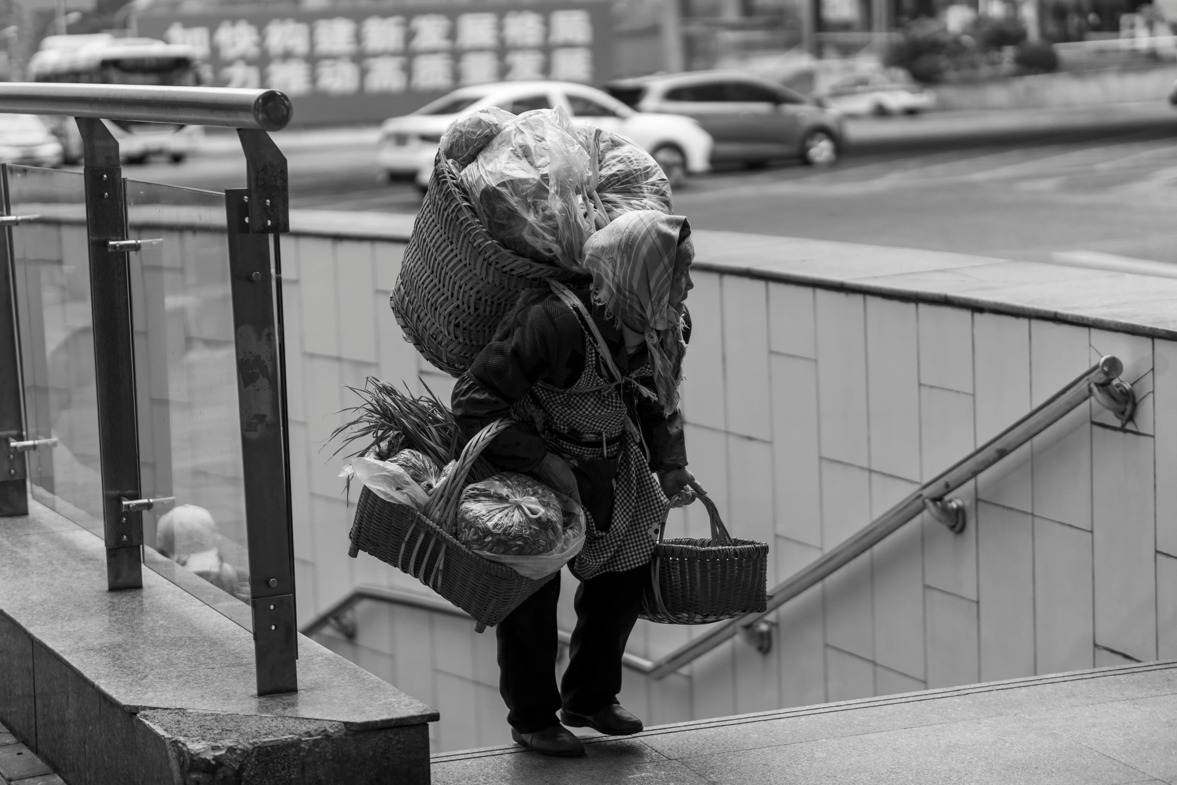 a black and white image of a woman carrying luggage