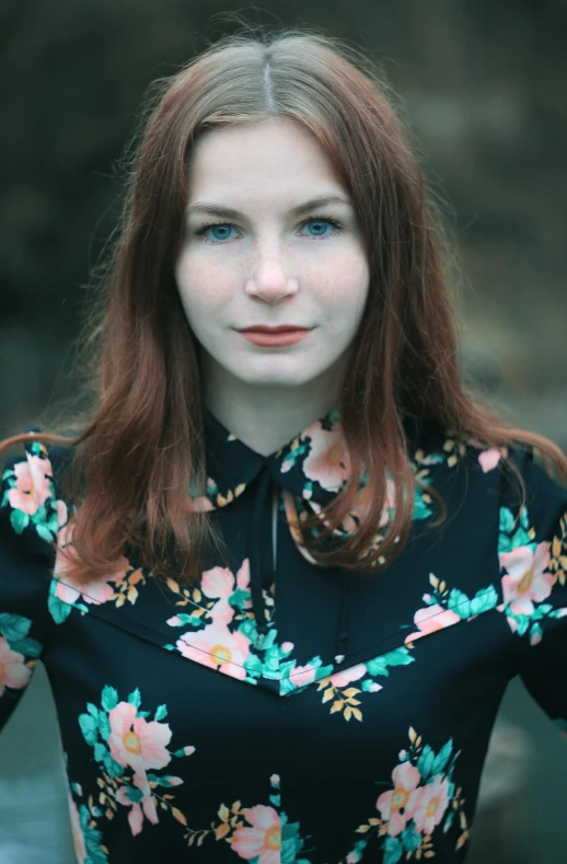 a beautiful young lady with red hair is posing for a portrait