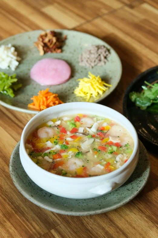 a bowl of soup next to plates of vegetables