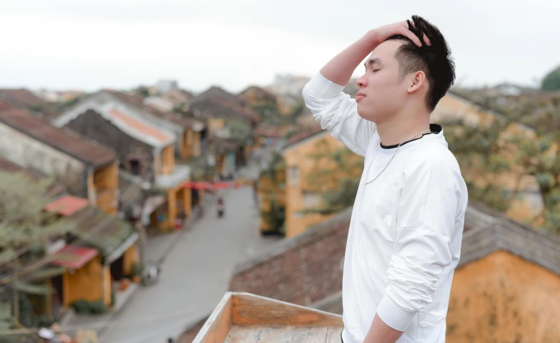 a man holding his hair up above his head