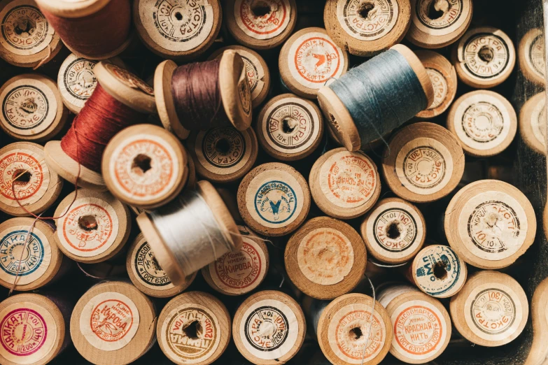 an arrangement of thread and spools sitting on a shelf