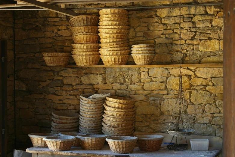 stacks of baskets are stacked on shelves by a wall
