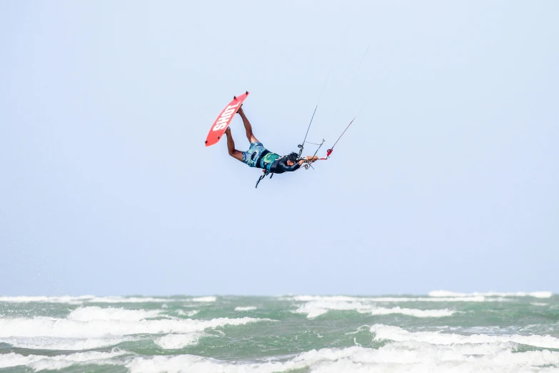 a person in blue is on a para sail and waves