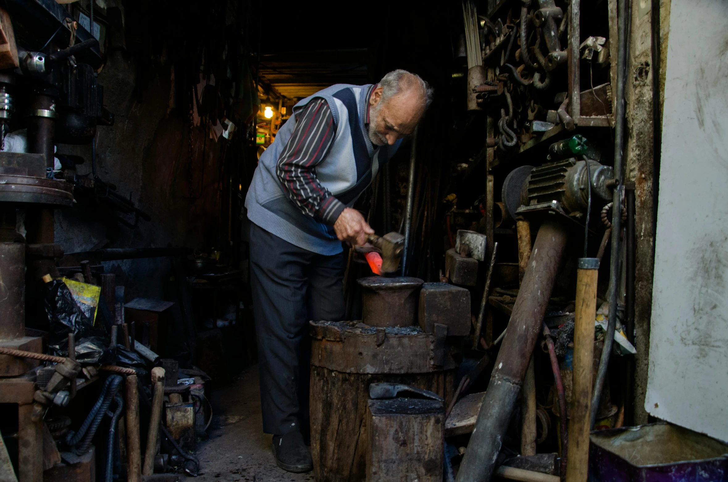 an older man working inside of a workshop