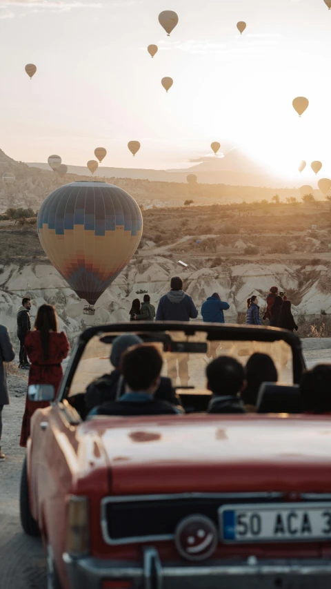 a car on a dirt road near  air balloons