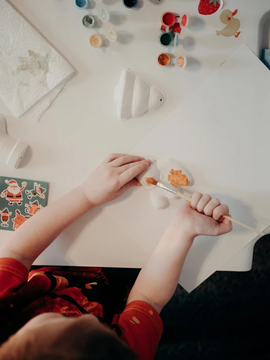 young child painting in the studio with a big paintbrush